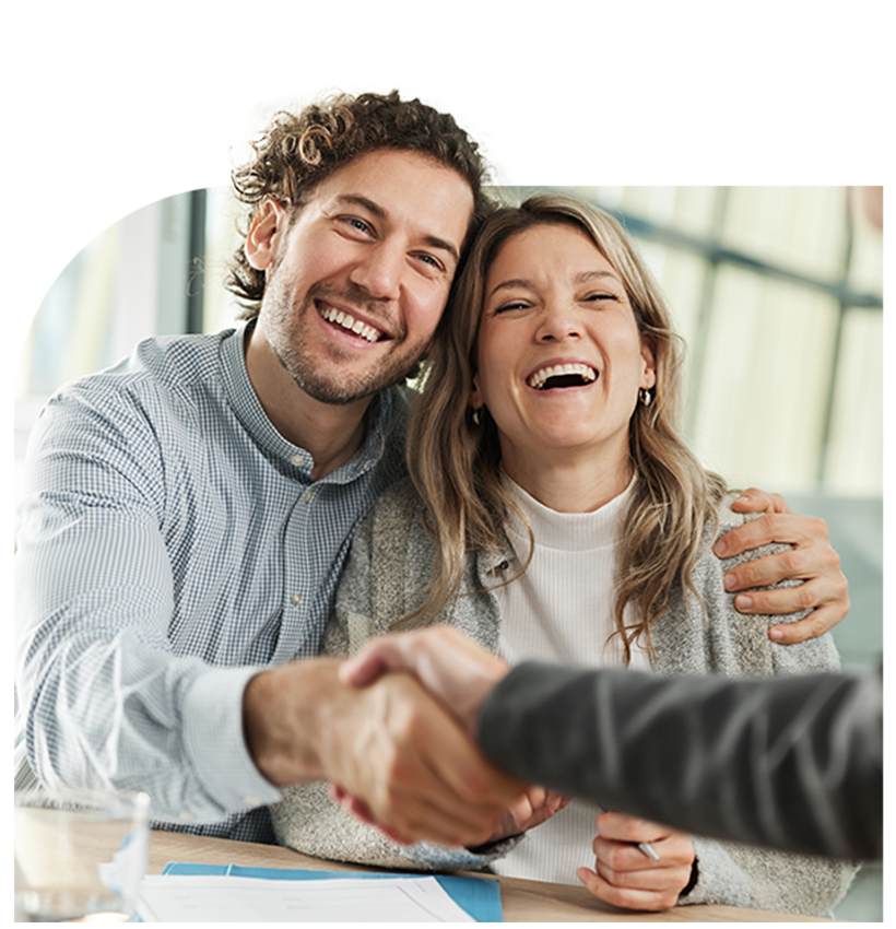 A couple shake hands with a loan officer